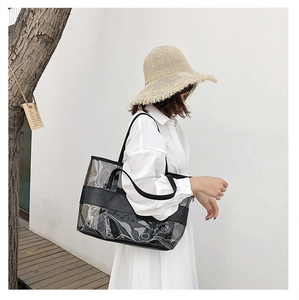 Waterproof PVC tote bag with black leather trim worn by a model in a summer beach setting