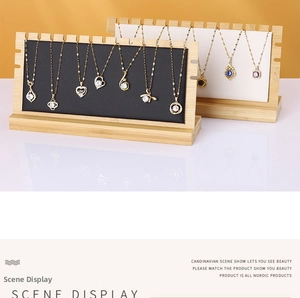 Close-up of minimalist bamboo jewelry stands with black and white necklace display boards