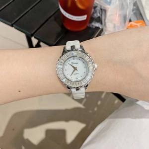 Close-up of white ceramic ladies watch with silver rhinestone bezel on a woman's wrist