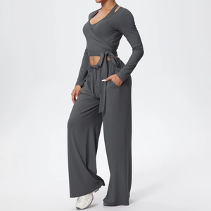 Détail d'un ensemble de yoga gris foncé avec haut croisé et pantalon évasé taille haute