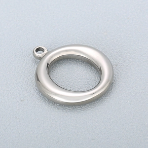 Polished stainless steel round hollow pendant with small loop on textured gray backdrop