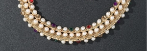 Detail of multi-layered pearls and colorful rhinestones on gold mesh luxury waist chain