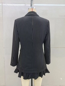 Détail de l'ourlet à volants doubles et rayures verticales sur le blazer noir femme