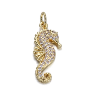 Detailed close-up of a gold-toned seahorse pendant with sparkling pink zircon stones