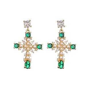 Exquisite gold-plated cross earrings with green gemstones and white pearls on white background