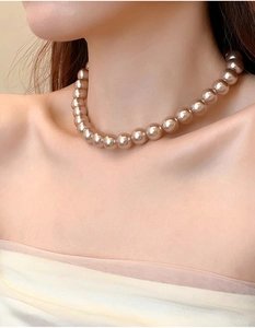 Close-up of champagne pearl necklace with high luster on model's collarbone
