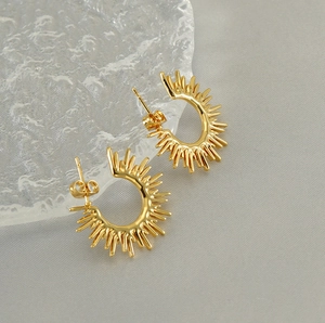 Detailed view of gold-plated sunburst fan-shaped stud earrings in a C-ring design