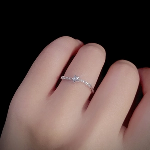 Minimalist S925 sterling silver star ring with zircons on a hand with black background