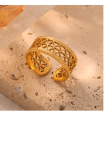 Detail of gold adjustable ring featuring hollow geometric mesh and woven edge texture