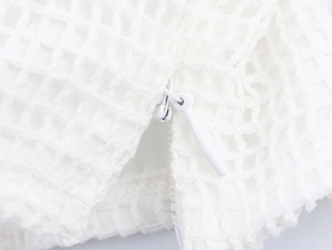 Détail macro du tissu en maille blanche de qualité et de la fermeture éclair invisible