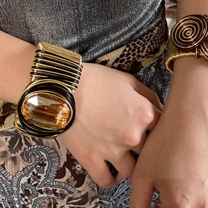 Macro shot of a twisted wire cuff bracelet featuring a large amber crystal gemstone