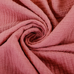 Macro shot of dark red double-layer cotton gauze fabric with soft crinkle texture