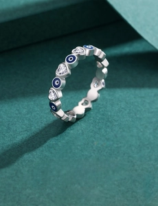 Detailed view of silver heart ring with blue evil eye motifs and sparkling zirconias