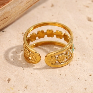 Detail of 18K gold-plated open ring with cutout flower design and colorful enamel inlay