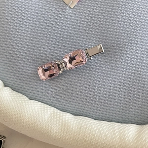 Detailed view of pink heart crystal hair clip with rhinestones on a silver metal base