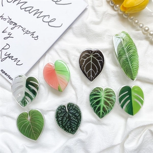 Set of 8 tropical leaf pattern phone grip stands with heart and leaf shapes on white fabric