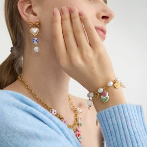 Detail of vintage ceramic tulip and freshwater pearl bracelet on a model's wrist