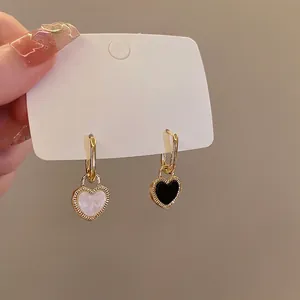 Retro gold heart hoop earrings with reversible black and white enamel and pearl shell design