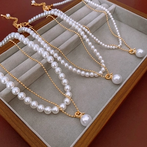 Détail macro de colliers de perles dorées multicouches avec pendentifs sur velours