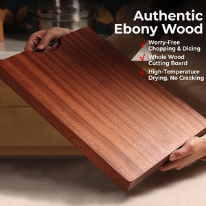 Solid ebony wood cutting board with metal handle held by hands in a kitchen setting