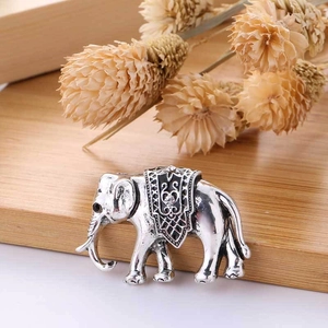 Detailed close-up of a vintage silver elephant brooch with black enamel and sparkling diamond