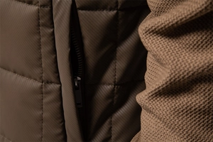 Detailed macro view of deep brown quilted texture with hidden zipper and ribbed cuff