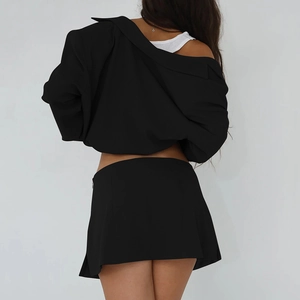 Back view of a woman wearing a black long sleeve shirt and sexy mini skirt outfit