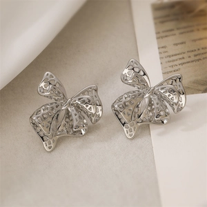 Detail view of silver hollow mesh bow earrings with 18K gold plated vintage finish