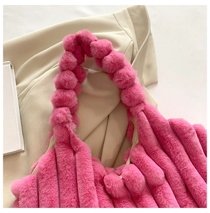 Detail of soft plush tote bag in rose pink featuring vertical striped faux fur texture