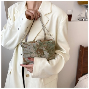 Detail of floral jacquard rectangular handbag with silver chain and metal clasp