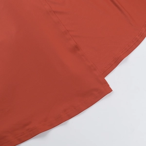 Primer plano de tela de vestido rojo óxido con dobladillo de doble costura y acabado satin