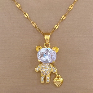 Macro shot of gold bear pendant necklace with large oval gemstone and pavé diamonds