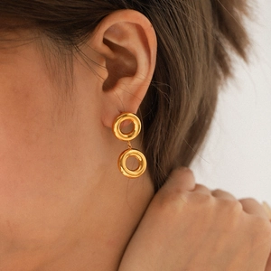 Élégantes boucles d'oreilles créoles doubles en acier inoxydable doré 18K sur un modèle