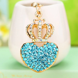 Close-up of golden crown and heart keychain with sparkling blue and clear rhinestones