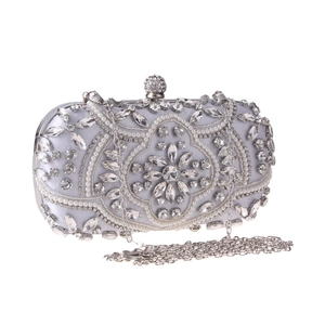 Macro shot of silver evening bag featuring intricate pearl beadwork and sparkling rhinestones