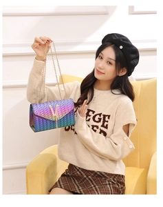 Détail d'un sac bandoulière tissé dégradé tissé avec bandoulière chaîne dorée et boucle métal en V