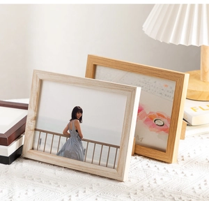 Detail of minimalist natural wood photo frame showing authentic grain and texture on desk