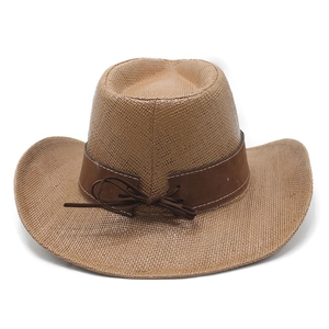 Detail of tan woven cowboy hat with brown faux leather band and bow on white background