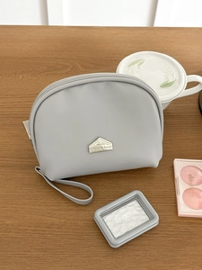Mini semi-circle waterproof makeup pouch in light gray PU with wrist strap and metal plaque