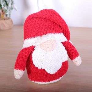 Handcrafted knitted Christmas Rudolf gnome doll decoration on a wooden surface