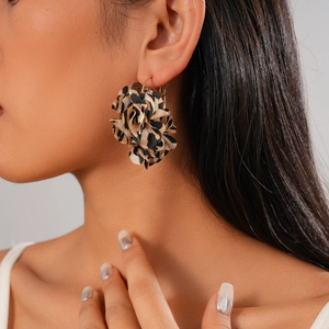 Macro shot of a 3D leopard print fabric flower earring with gold hook on model