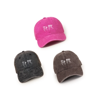 Washed cotton baseball caps in rose, black, and brown with dancing skull embroidery