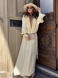 Elegante abito lungo giallo con scollo a V, volant e cappello di paglia beige stile street