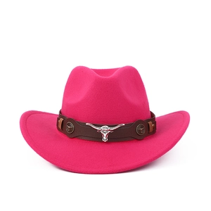 Détail d'un chapeau de cow-boy rose avec bande en cuir marron et emblème tête de taureau