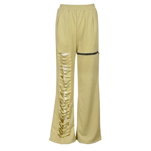 Detail of khaki wide-leg pants featuring hollow-out cutouts and a decorative side zipper