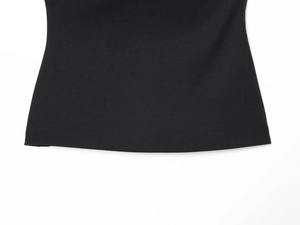 Gros plan du haut décontracté noir montrant la texture du tricot et les coutures de l'ourlet