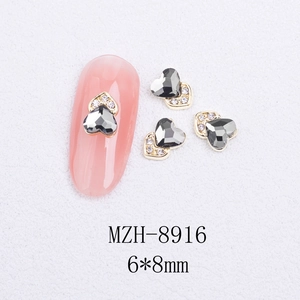 Macro shot of 6x8mm heart-shaped grey cat eye nail art charm with gold rhinestones