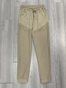 Detail view of khaki joggers featuring a unique spliced design and drawstring waist