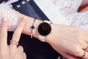 Detail of Hannah Martin leather watch with rose gold clover bracelet and rings set