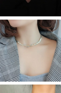 Detailed close-up of a two-tone 18K gold and silver triple-strand braided snake chain